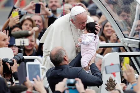 Pope Francis kisses a baby as he arrives to lead the general audience in Saint Peter's Square at the Vatican October 26, 2016. REUTERS/Max Rossi