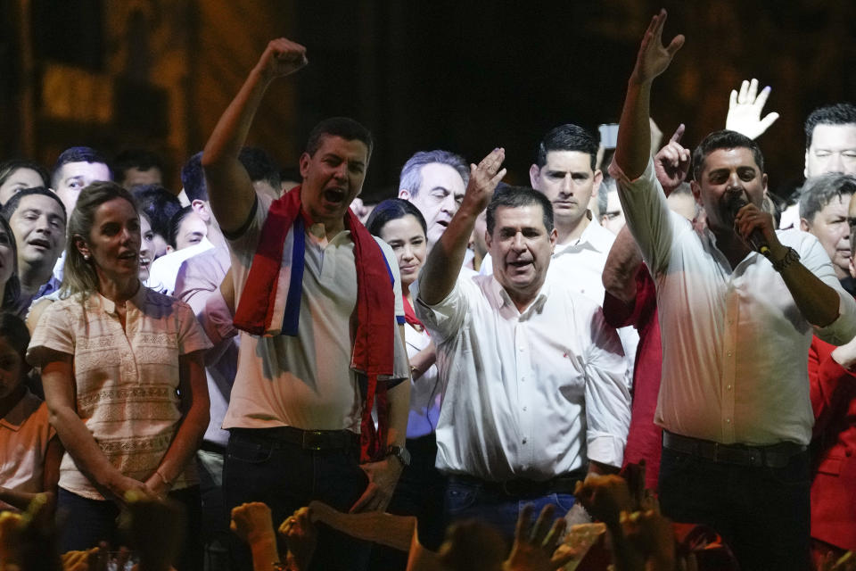 Santiago Peña, segundo a la izquierda, candidato presidencial del gobernante Partido Colorado, el expresidente de Paraguay Horacio Cartes, segundo por la derecha, y el compañero de binomio de Peña Pedro Alliana, a la derecha, festejan tras el cierre de votaciones en las elecciones generales, en Asunción, Paraguay, el domingo 30 de abril de 2023. (AP Foto/Jorge Sáenz)