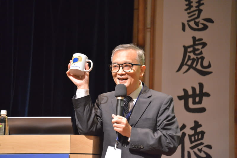 台北慈濟醫院楊緒棣副院長展示研討會紀念品，並以「甘願做，歡喜受」表達慈濟的人文精神。