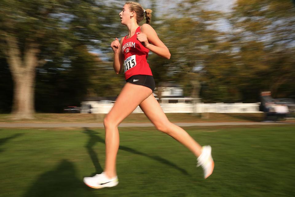 Hingham’s Clare Lowther is a blur of motion during a lap of the athletic fields in their dual meet against Marshfield at Hingham High on Wednesday, Oct. 11, 2023. She would finish second with a time of 18:54.9. Marshfield boys won 27-28 while Marshfield girls won 19-36.