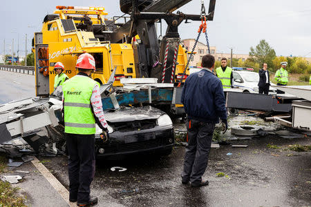 Emergency workers lift a road sign that fell on a car following a storm that tore through western Romania, in Timisoara, Romania September 17, 2017. Inquam Photos/Cornel Putan Alin/via REUTERS