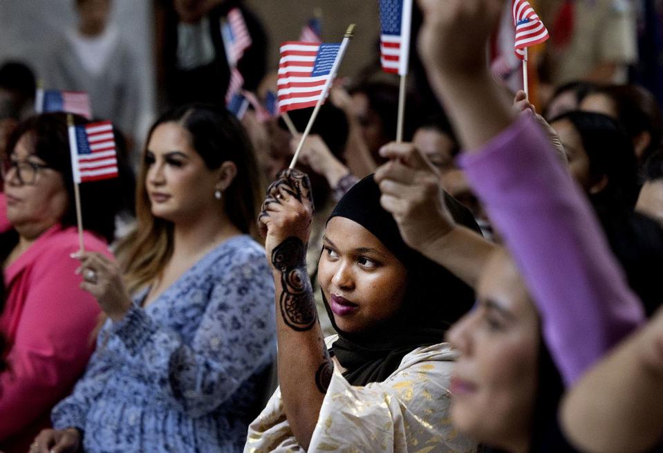 Citizen applicants wave American flags during a naturalization ceremony to become citizens of the United States at the Capitol in Salt Lake City on Wednesday.