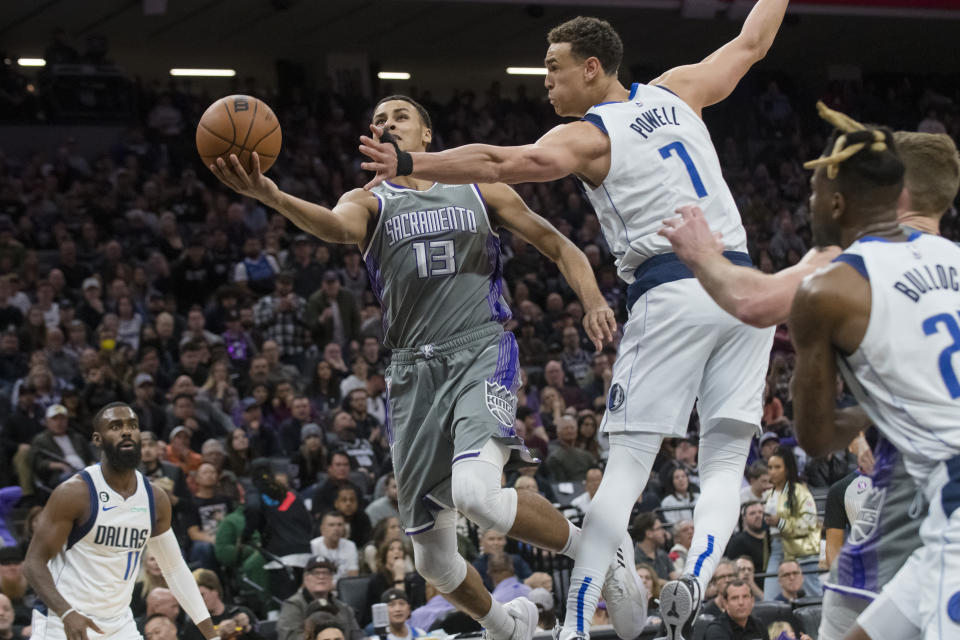 Sacramento Kings forward Keegan Murray (13) drives to the basket past Dallas Mavericks center Dwight Powell (7) during the second half of an NBA basketball game in Sacramento, Calif., Friday, Feb. 10, 2023. The Mavericks won 122-114. (AP Photo/Randall Benton)