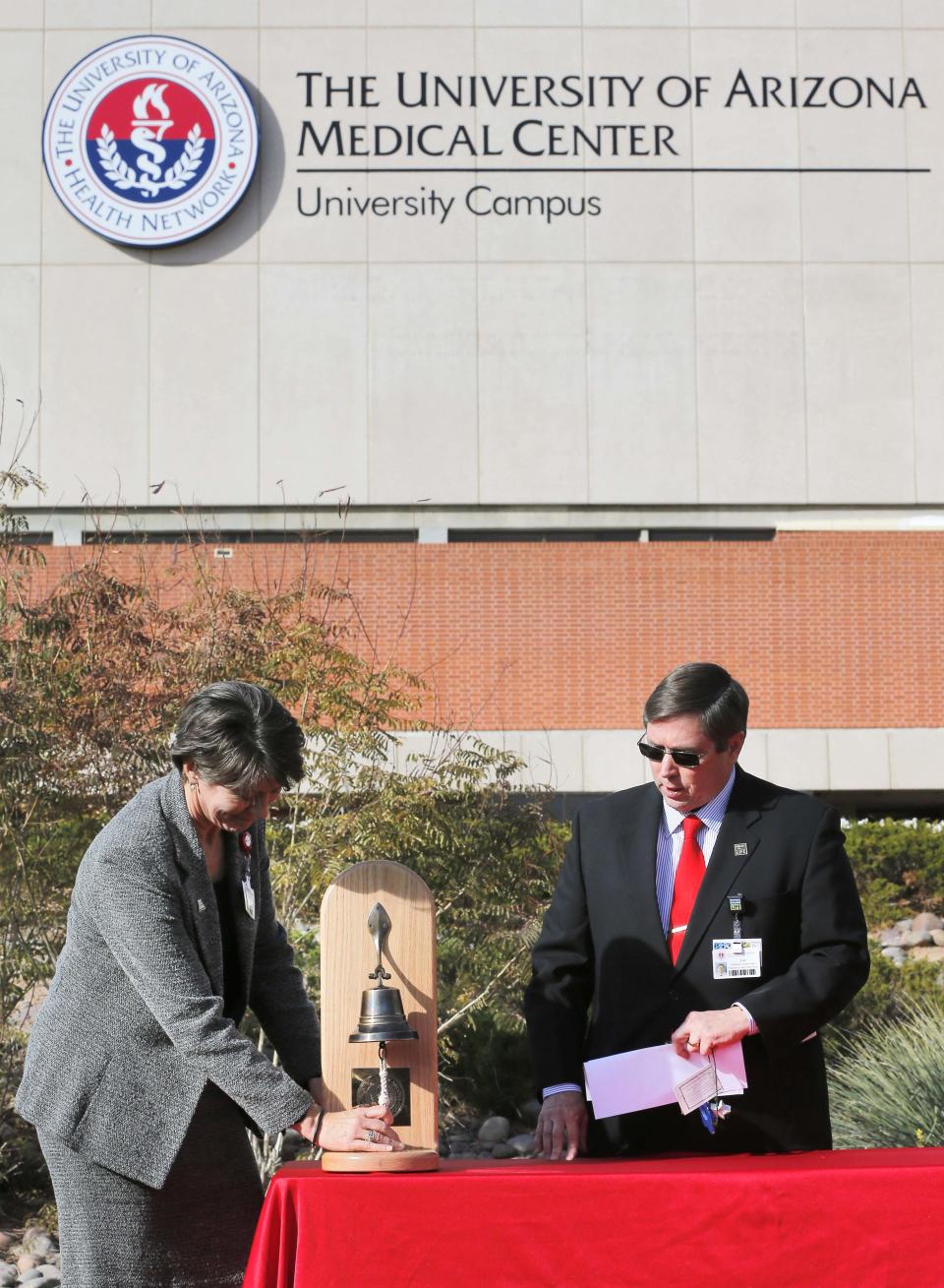 Karen Mlawsky, CEO of the University of Arizona Medical Center Hospital Division, rings a bell 19 times in honor of the 19 shooting victims during a remembrance ceremony on the third anniversary of the Tucson shootings, Wednesday, Jan. 8, 2014, in Tucson, Ariz. as Chaplin Joe Fitzgerald looks on. Six people were killed and 13 wounded, including U.S. Rep. Gabrielle Giffords, D-Ariz., in the shooting rampage at a community event hosted by Giffords in 2011. Jared Lee Loughner was sentenced in November 2012 to seven consecutive life sentences, plus 140 years, after he pleaded guilty to 19 federal charges in the shooting. (AP Photo/Matt York)