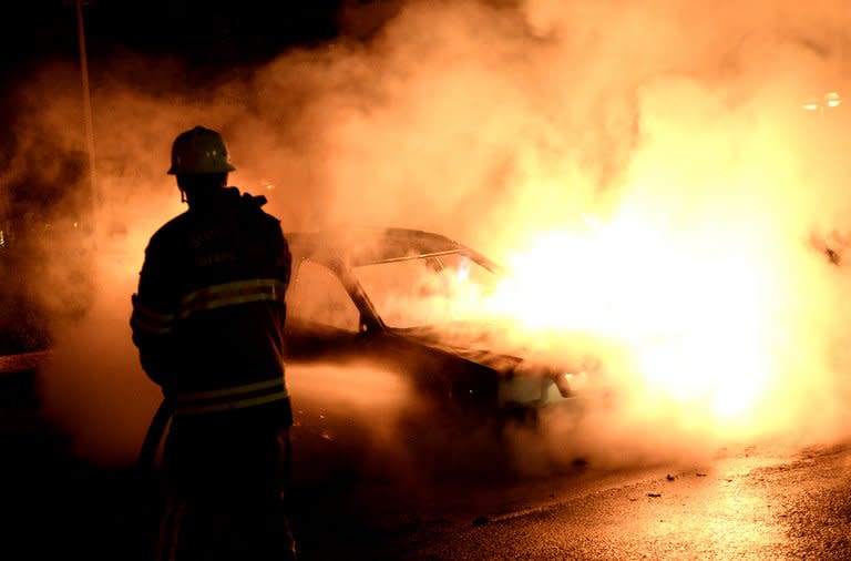 Firemen extinguish a burning car in Kista after youths rioted in few differant suburbs around Stockholm, on May 21, 2013. Rioters have torched cars and attacked local police stations in 15 immigrant-populated Stockholm suburbs in a fourth night of riots, shattering Sweden's image as a peaceful and egalitarian nation