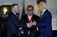 President Joe Biden greets David Furnish, husband of Elton John, after Biden presented him with a National Humanities Medal after a concert on the South Lawn of the White House in Washington, Friday, Sept. 23, 2022. (AP Photo/Susan Walsh)