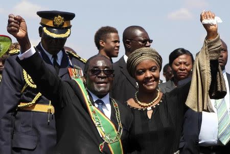Zimbabwe President Robert Mugabe (L) and his wife Grace (R) greet supporters at a national Heroes Day rally in Harare, August 11, 2014. REUTERS/Philimon Bulawayo