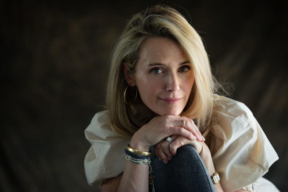 Jennifer Siebel Newsom in front of a dark background, leaning her chin on her hands