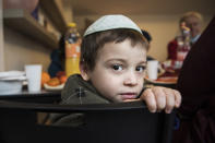 Mendel, a boy from an orphanage in Odesa, Ukraine, sits after his arrival at a hotel in Berlin, Friday, March 4, 2022. More than 100 Jewish refugee children who were evacuated from a foster care home in war-torn Ukraine and made their way across Europe by bus have arrived in Berlin. (AP Photo/Steffi Loos)