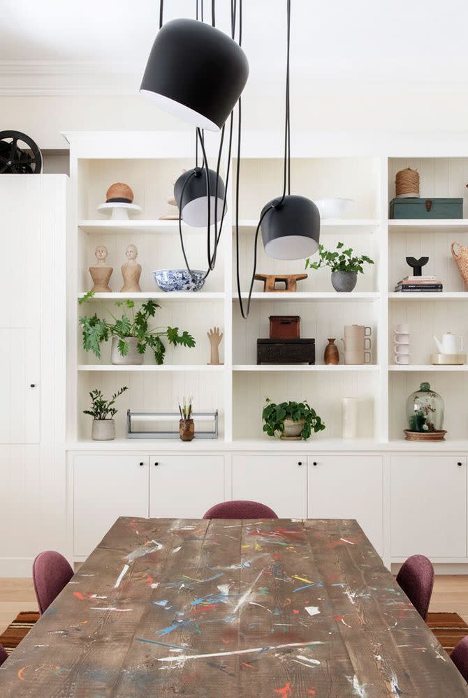 a table with a lamp and a shelf with objects on it