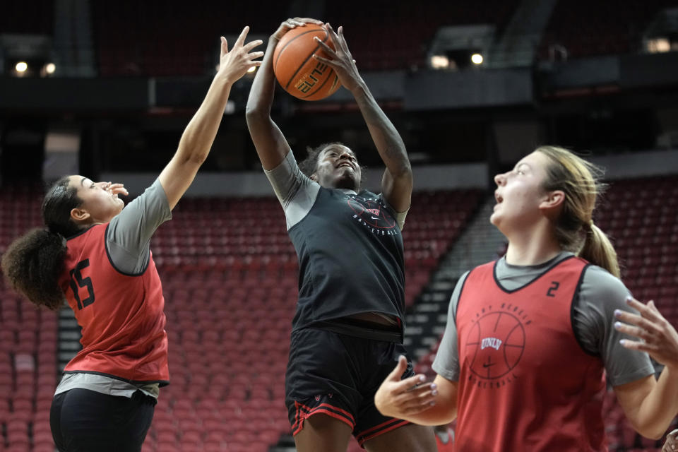 UNLV NCAA college basketball center Desi-Rae Young, center, grabs a rebound over center Keyana Wilfred during practice Wednesday, Feb. 15, 2023, in Las Vegas. This season the Lady Rebels are repeat Mountain West champions and ranked at No. 24 in the AP poll for the first time in 29 years.(AP Photo/John Locher)