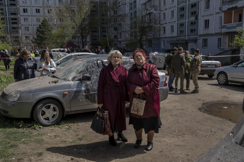 Residents watch the destruction of a residential building that was hit during a Russian attack in Uman, central Ukraine, Friday, April 28, 2023. (AP Photo/Bernat Armangue)
