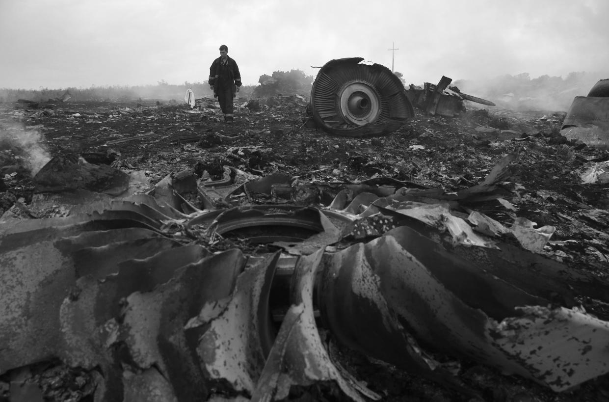 A man walks amid debris from a plane crash.