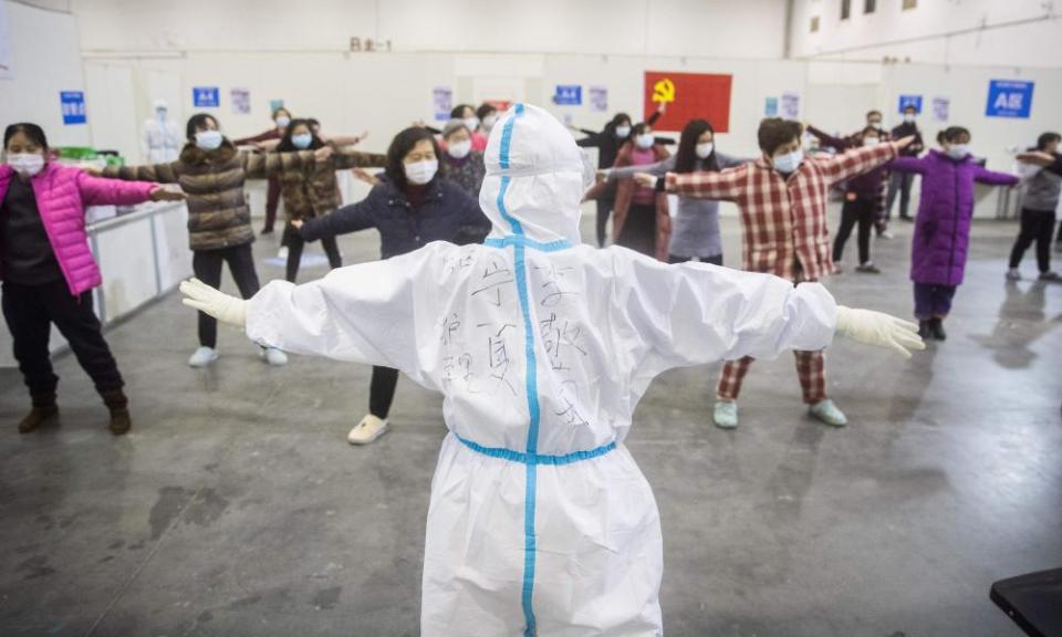 Patients with mild symptoms of coronavirus take part in group exercises at a temporary hospital in Wuhan.