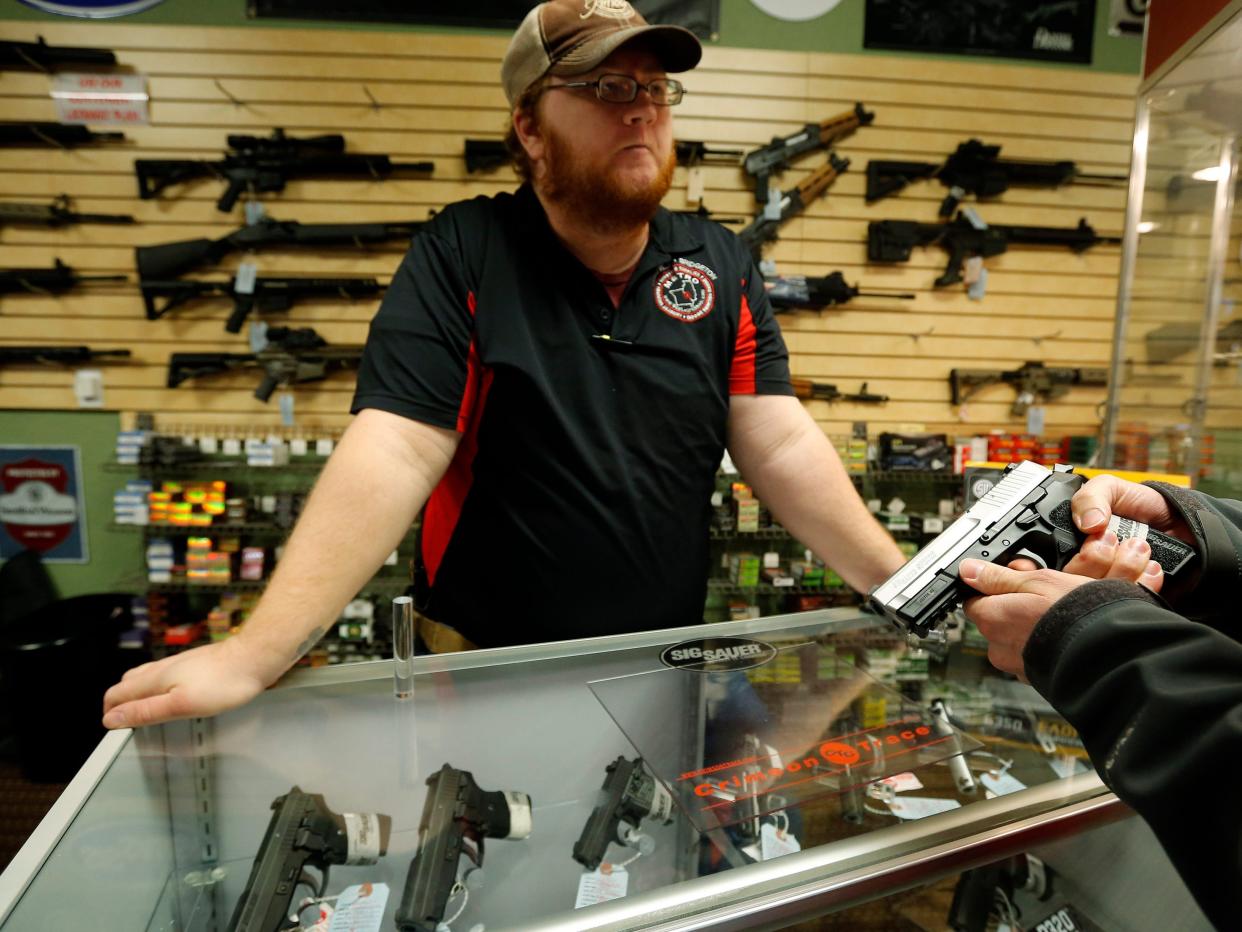 Metro Shooting Supplies' employee speaks to a customer about the purchase of a 9mm handgun in Bridgeton, Missouri.