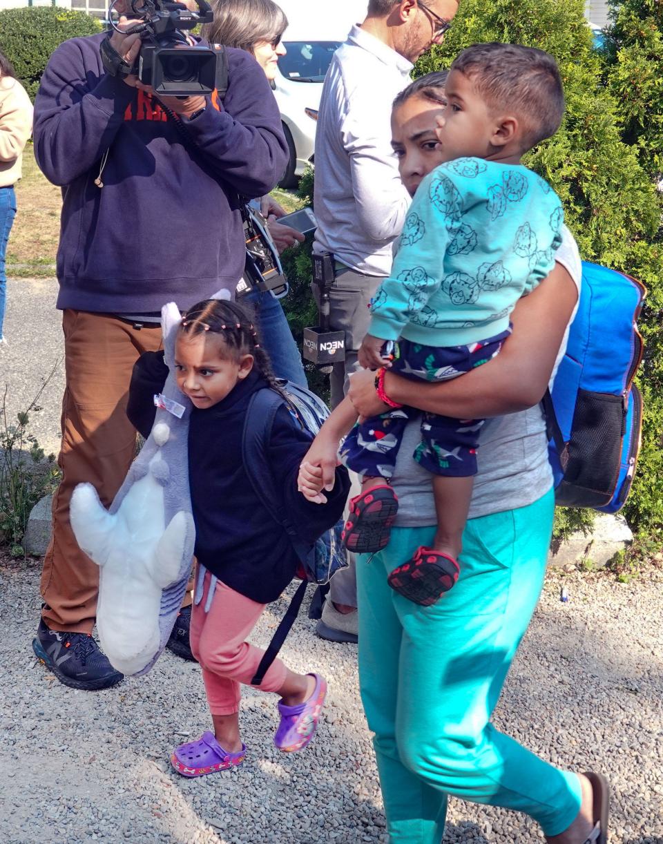 A migrant family makes their way on Friday to a bus that would transport them from St. Andrews church in Edgartown, Massassachusetts to Vineyard Haven, on their way to a military base on nearby Cape Cod.