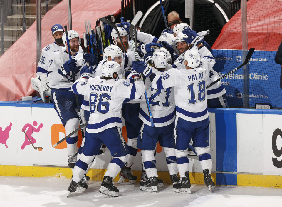 Teammates mob Tampa Bay Lightning defenseman Brayden Point (21) after he scored the game winning goal against the Florida Panthers during the third period in Game 1 of an NHL hockey Stanley Cup first-round playoff series, Sunday, May 16, 2021, in Sunrise, Fla. (AP Photo/Joel Auerbach)
