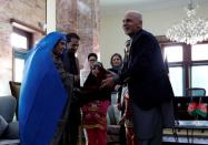 Sharbat Gula (L), the green-eyed "Afghan Girl" whose 1985 photo in National Geographic became a symbol of her country's wars, receives a key to an apartment from Afghanistan's President Ashraf Ghani, after she arrived in Kabul, Afghanistan November 9, 2016. REUTERS/Mohammad Ismail