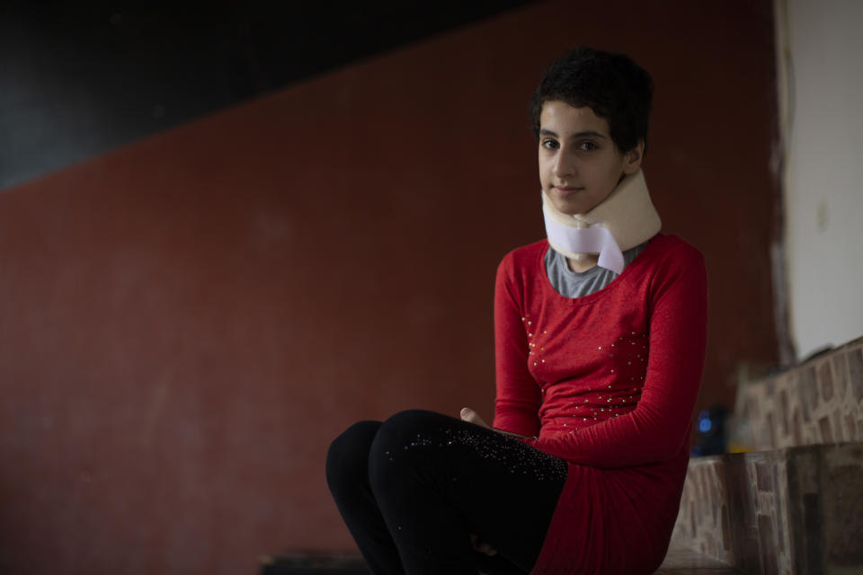 Hoda Kinno, 11, poses for a photograph at a temporary apartment in the coastal town of Jiyeh, south of Beirut, Lebanon, Tuesday, Sept. 22, 2020. The Kinno family from Syria's Aleppo region was devastated in the wake of the Aug. 4 explosion at the Beirut port -- Hoda suffered a broken neck and other injuries and her sister Sedra, 15, died in the explosion. (AP Photo/Hassan Ammar)