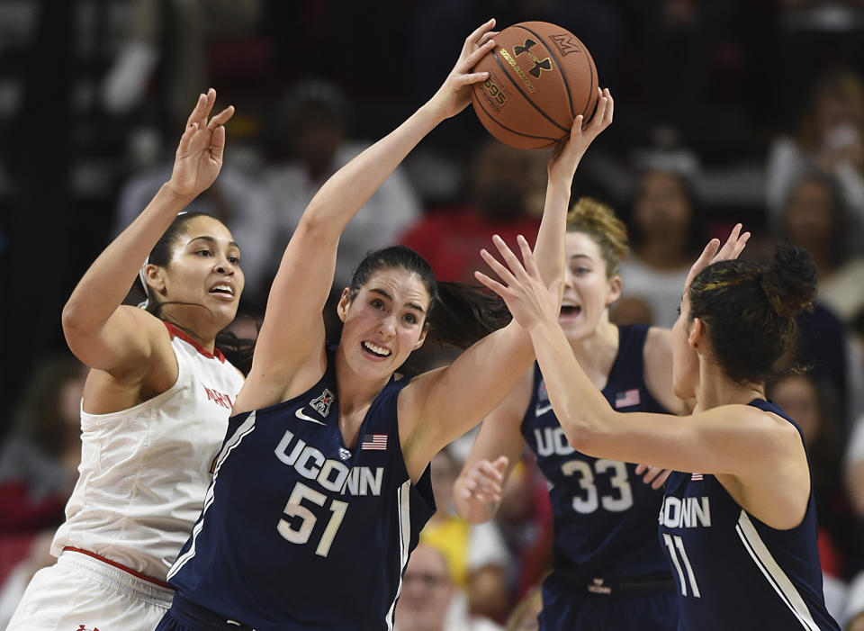 Connecticut's Natalie Butler, center, pulls down a rebound against Maryland during the second half of an NCAA college basketball game, Thursday, Dec. 29, 2016 in College Park, Md. Connecticut won 87-81. (AP Photo/Gail Burton)