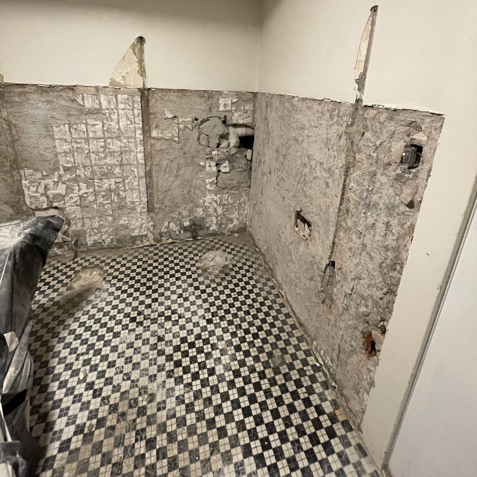 A hole in the corner of a wall at the Plaza Theatre in Atlanta. A closet space was found behind the hole, revealing items from decades ago such as a popcorn bucket, alcohol bottles and a wallet.