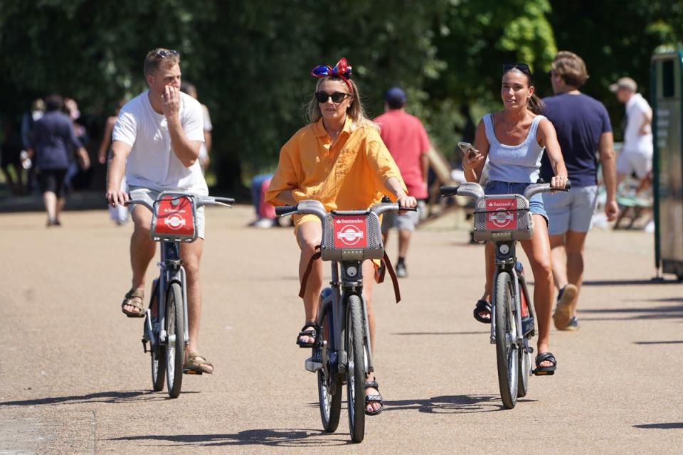 People cycling through Hyde Park, London in July  (PA)