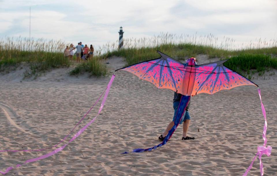 Vacationers gather for photographs at the Cape Hatteras Lighthouse or to fly a kite on the Cape Hatteras National Seashore on Tuesday, July 13, 2021 in Buxton, N.C.