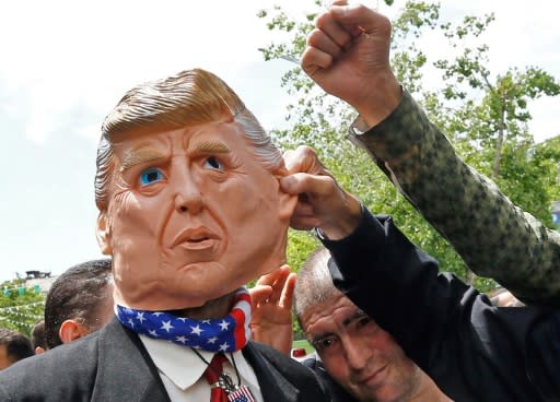 Iranians protest using a mask depicting US President Donald Trump during a rally in Tehran on May 19, 2019