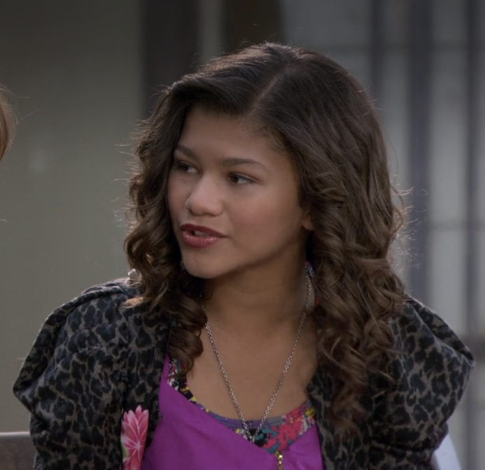 Zendaya, in patterned jacket over bright top, with wavy hair, on "Shake It Up"