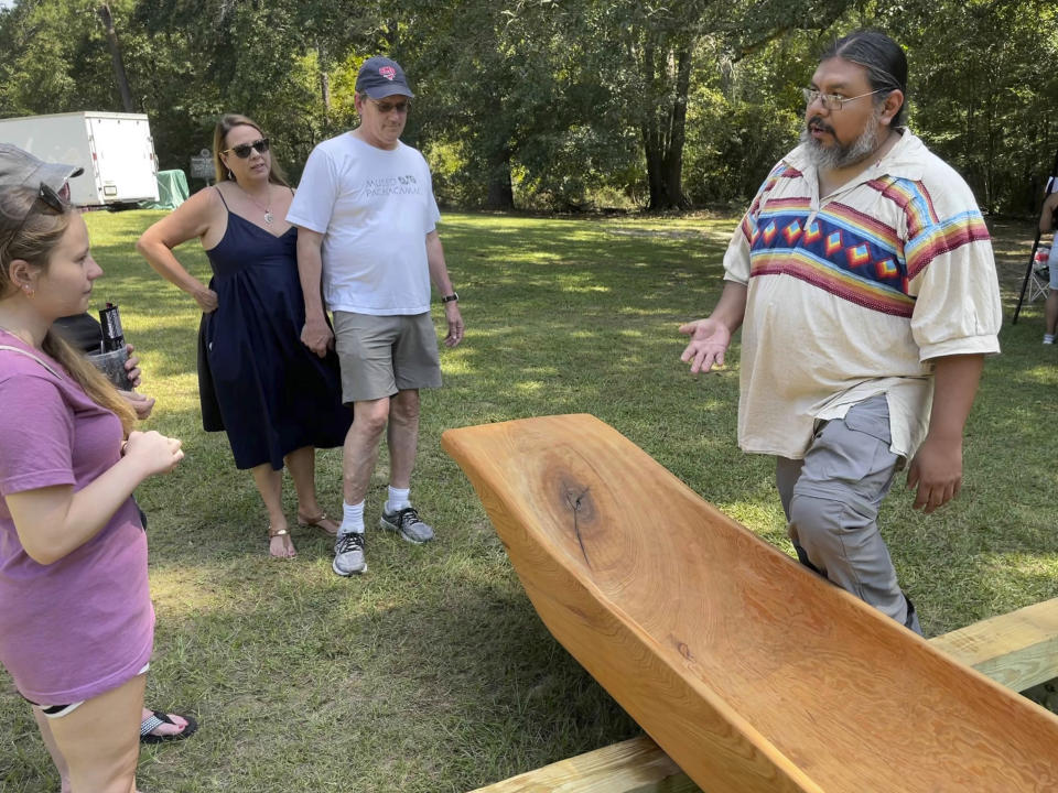 Pedro Zepeda, of the Seminole Tribe of Florida, explains how he and Muscogee elder John John Brown carved a traditional canoe from a cypress tree, on Saturday, Sept. 17, 2002, in Macon, Ga. (AP Photo/Michael Warren)