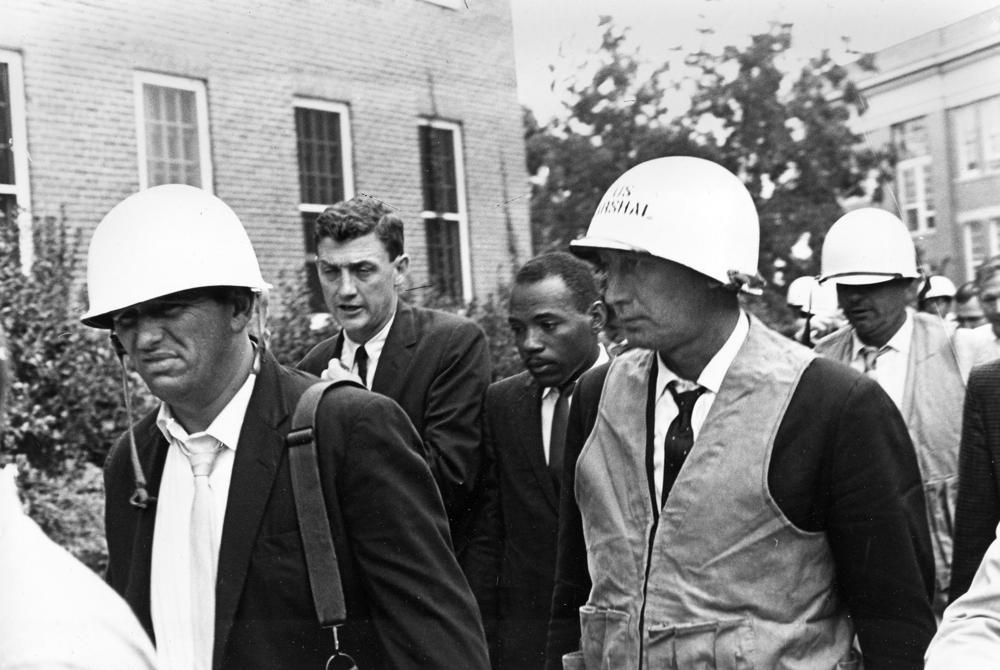 James Meredith, center right, is escorted by federal marshals as he appears for his first day of class at the University of Mississippi, in Oxford, Mississippi, Oct. 1, 1962. (AP Photo/File)
