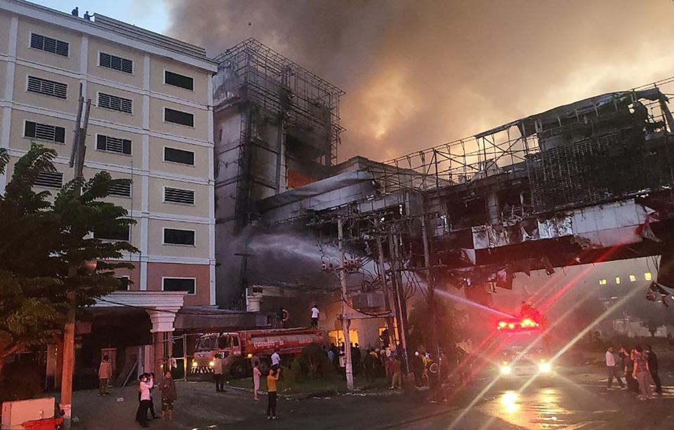 Firefighters spray water onto the site of a fire at the Grand Diamond City hotel-casino in Poipet on December 29, 2022. - As many as 10 people have died in a fire at a Cambodian hotel-casino on the border of Thailand, with photos showing groups desperately huddled on ledges as fierce flames surround them.