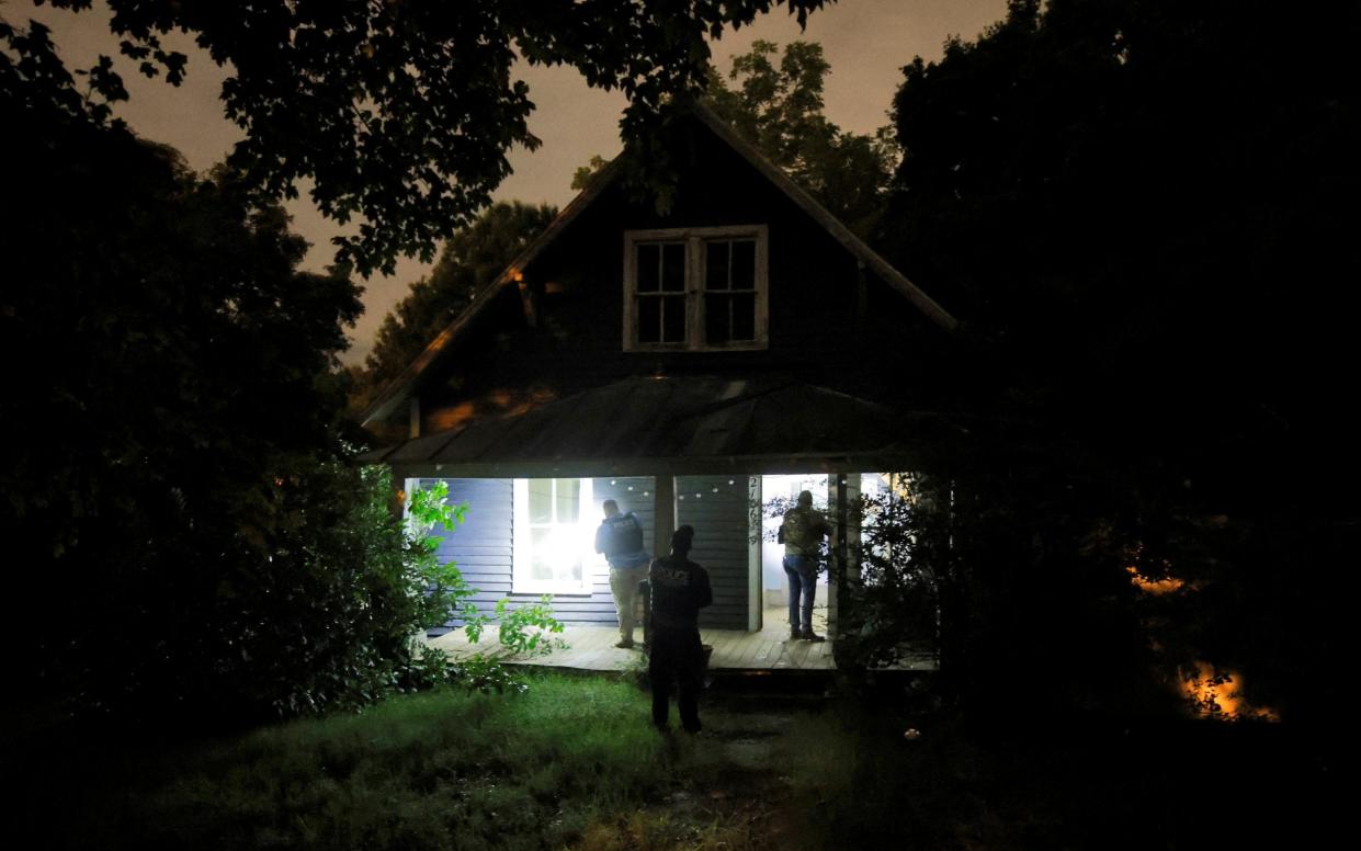 Secret Service and Homeland Security agents check a former home of the suspect