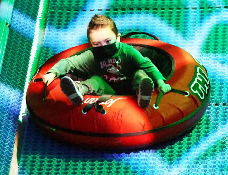 Bradley Bowes, 5, of Rockland, goes tubing at the "Enchanted Village" at Jordan's Furniture in Avon on Saturday, Nov. 13, 2021.