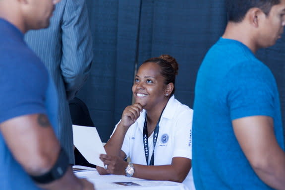 A Virgin Galactic employee interacts with visitors at the company's Career Day event on Sept. 7, 2013, at Mojave Air and Space Port in Mojave, Calif.