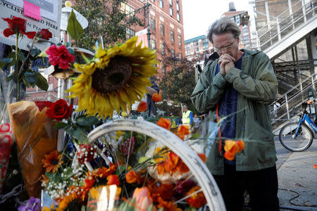 A man prays after laying flowers at an existing roadside memorial, or a ghost bike, that is now used to remember the victims of the Tuesday's attack alongside a bike path at Chambers Street in New York City, in New York, U.S., November 2, 2017. REUTERS/Shannon Stapleton