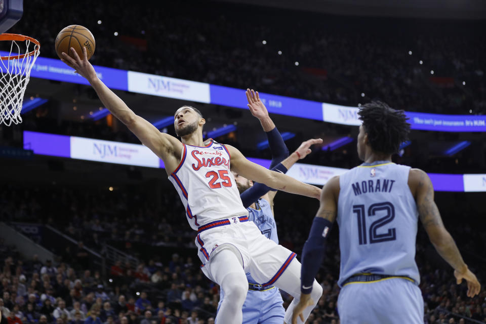 Philadelphia 76ers' Ben Simmons, left, goes up for a shot against Memphis Grizzlies' Jonas Valanciunas, center, and Ja Morant during the first half of an NBA basketball game Friday, Feb. 7, 2020, in Philadelphia. (AP Photo/Matt Slocum)