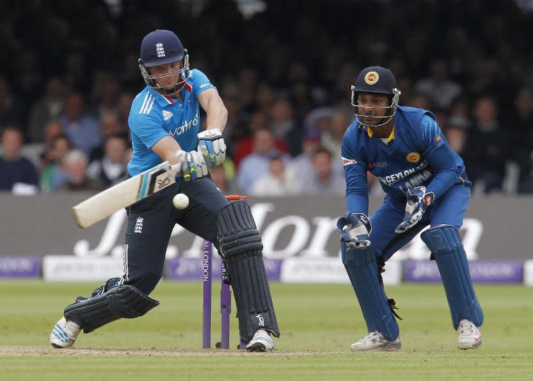 England's Jos Buttler (L) plays a shot beside Sri Lankan wicketkeeper Kumar Sangakkara during the fourth ODI at Lord's cricket ground on May 31, 2014