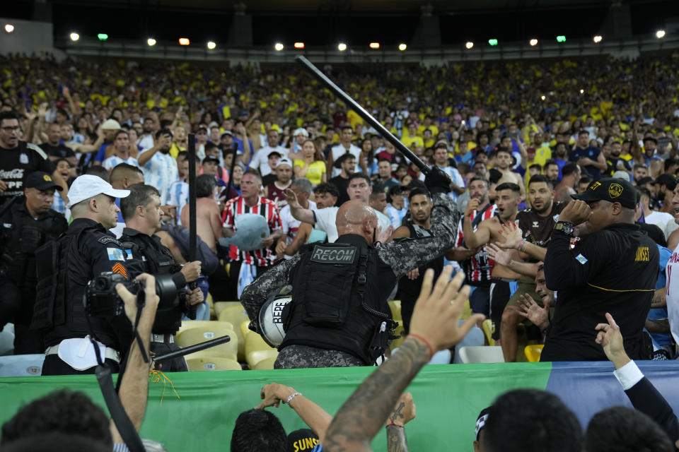 Police try to stop a fight between Brazilian and Argentinian fans prior to a qualifying soccer match for the FIFA World Cup 2026 at Maracana stadium in Rio de Janeiro, Brazil, Tuesday, Nov. 21, 2023.(AP Photo/Silvia Izquierdo)