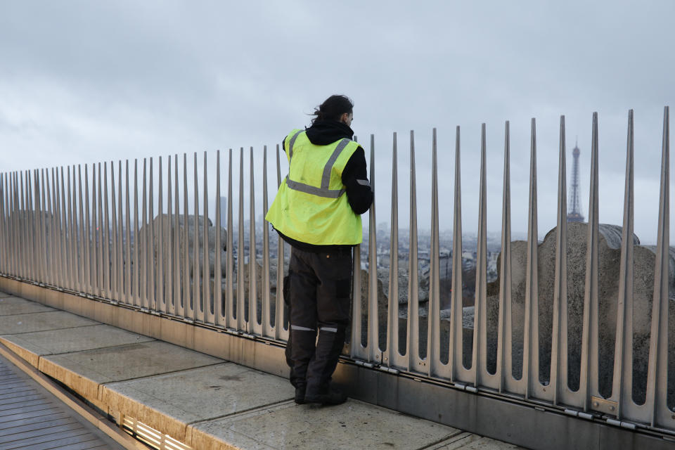 A demonstrator watches from the top of the Arc de Triomphe on the Champs-Elysees avenue during a demonstration Saturday, Dec.1, 2018 in Paris. Demonstrations against rising taxes turned into scenes of rioting in Paris city center as at least 65 people including 11 police officers have been injured in violent protests in the French capital. (AP Photo/Kamil Zihnioglu)