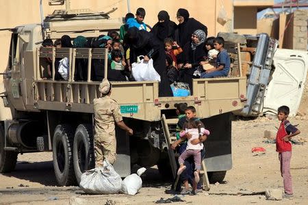 Displaced Iraqi people who fled from clashes ride in a military truck during a battle between Iraqi forces and Islamic state militants in western Mosul, Iraq, May 17, 2017. REUTERS/ Alaa Al-Marjani