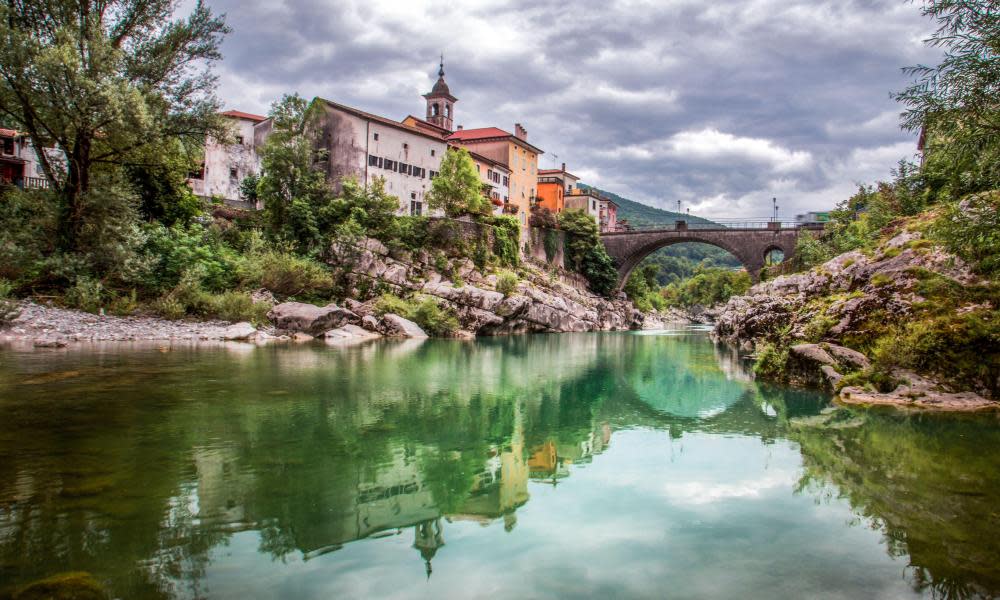 The Soča canal’s green, clean water beside village