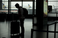 A passenger stands in front of Ryanair airline check-in desks during a Ryanair employees strike at the Charleroi airport, outside Brussels, Friday, Sept. 28, 2018. Ryanair pilots and cabin crew went on strike forcing the cancellation of some 250 flights across Europe, including Spain, Portugal, Belgium, the Netherlands, Italy and Germany. (AP Photo/Francisco Seco)