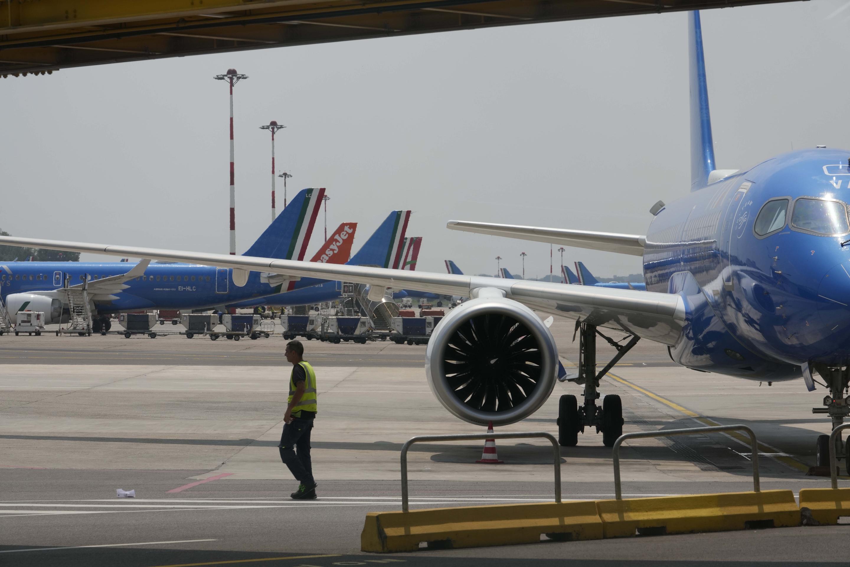 An airport baggage handler walks on the tarmac at Linate Airport in Milan.