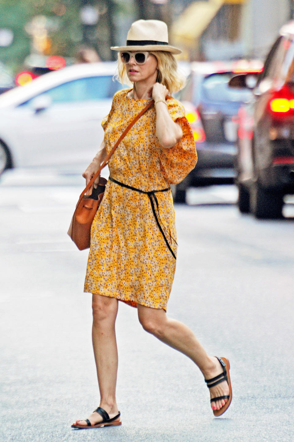 <p>Además de eso, un maxi bolso de asa larga en color marrón claro y estilo cartera juega con los tonos de las sandalias y con el naranja del vestido. El calzado son sandalias bajas, de suela marrón claro, con tiras negras y pie descubierto, ¡bien fresquitas!</p> 