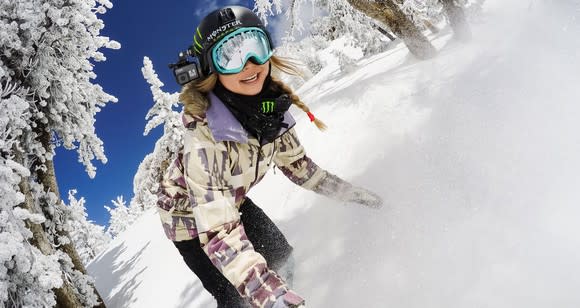 Woman snowboarding while using a GoPro camera