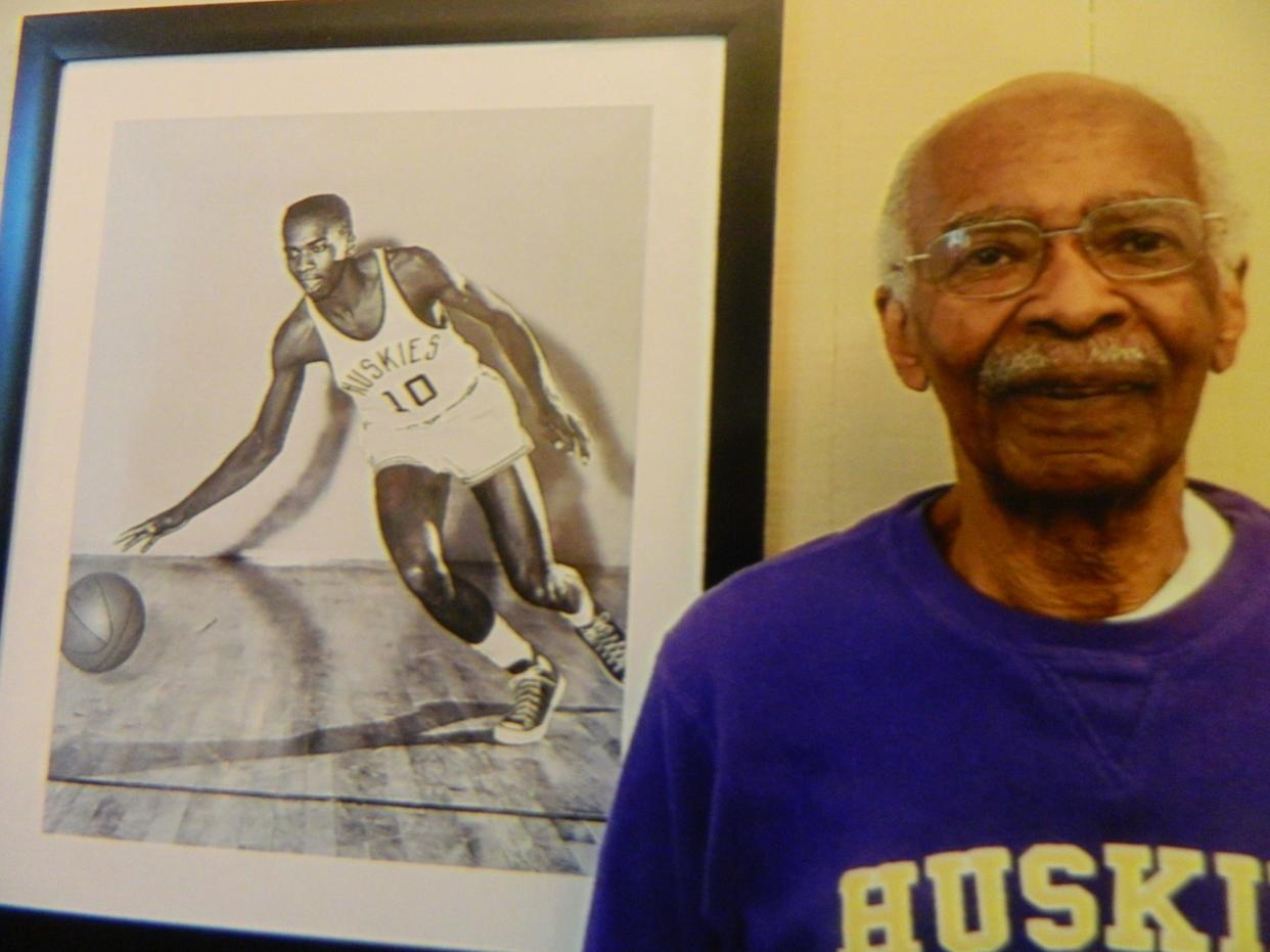 Dick Crews, now living in Renton, next to a photo from his college career, when he became the first Black basketball player at the University of Washington.