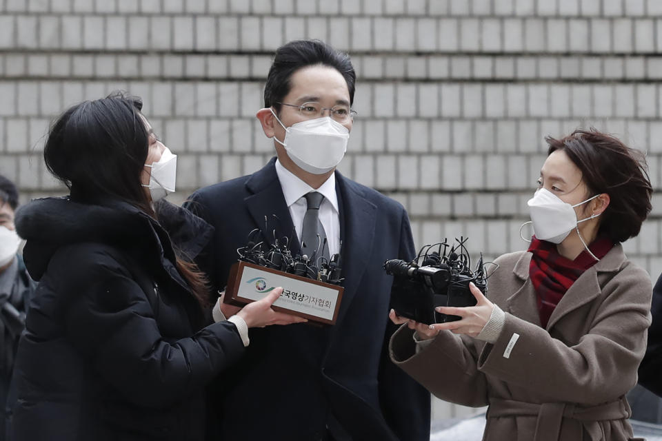 FILE- In this Jan. 18, 2021 file photo, Samsung Electronics Vice Chairman Lee Jae-yong, center, is questioned by reporters upon his arrival at the Seoul High Court in Seoul, South Korea, Monday, Jan. 18, 2021. In an announcement by Seoul’s Justice Ministry on Monday, Aug. 9, 2021, South Korea will release billionaire Lee on parole this week after he spent 18 months in prison for his role in a massive corruption scandal that triggered nationwide protests and ousted the country’s previous president. (AP Photo/Lee Jin-man, File)
