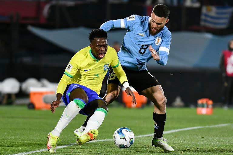 Nahitan Nández disputa la pelota con Vinicius Junior 