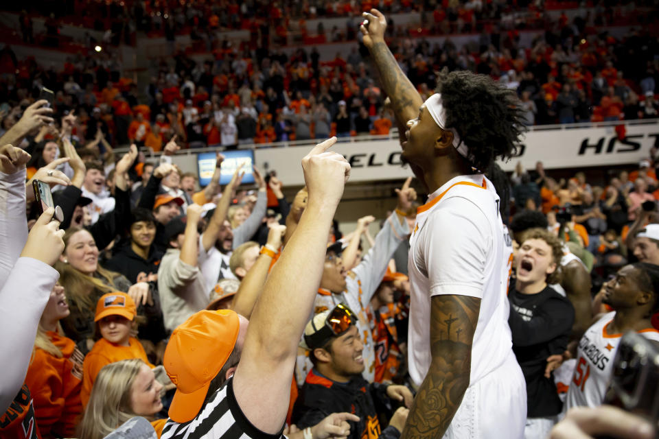 Oklahoma State's Woody Newton (4) celebrates with fans after the the NCAA college basketball game against Iowa State in Stillwater, Okla., Saturday, Jan. 21, 2023. (AP Photo/Mitch Alcala)